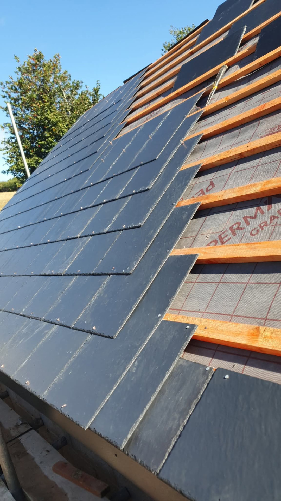 Slate roof covering laid over breathable membrane and treated battens